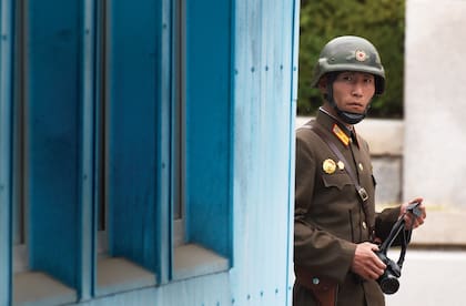 Cámara en mano, un soldado norcoreano mira hacia la zona sur del Panmunjoem