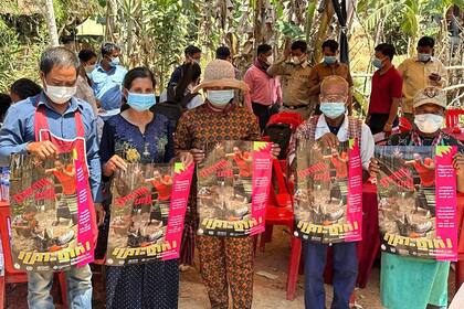 Esta imagen publicada por el Departamento de Control de Enfermedades Transmisibles de Camboya (CDCD) el 23 de febrero de 2023 muestra a los aldeanos posando con carteles sobre las amenazas del virus H5N1, en la provincia de Prey Veng