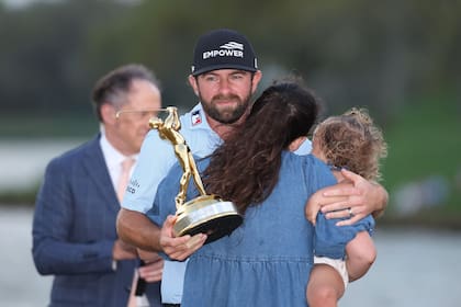Cameron Young y el abrazo con su esposa Kelsey y su hija Vivienne (Photo by Kevin C. Cox / GETTY IMAGES NORTH AMERICA / Getty Images via AFP)