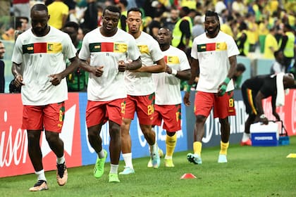Los jugadores de Camerún calientan antes del partido de fútbol del Grupo G de la Copa Mundial de Qatar 2022 entre Camerún y Brasil en el Estadio Lusail