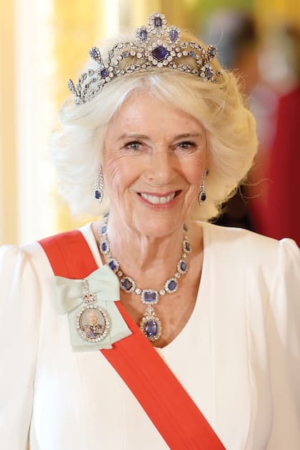 Camilla llevó una tiara que originalmente fue una gargantilla con 12 zafiros rodeados de diamantes, creada en 1850 para la princesa Luisa María de Bélgica. En 1963, Isabel II compró la gargantilla y la convirtió en una tiara, a juego con un colgante y pendientes de zafiros que le había regalado su padre, el rey Jorge VI. Y, La Reina lució ese conjunto durante la velada y, como Kate, sumó la Orden de Familia de Carlos III.