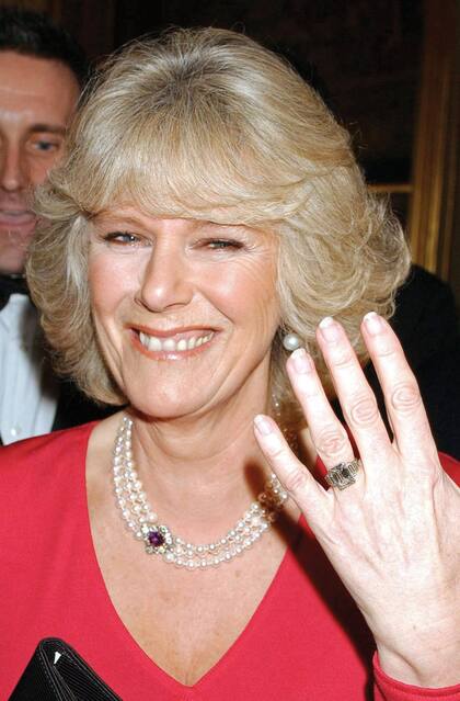 Radiante de felicidad, Camilla muestra su anillo de compromiso, una espectacular pieza de platino decorada en el centro con un diamante cuadrado y con tres tiras de diamantes a cada lado, perteneciente a la familia real. Era febrero de 2005 y faltaban dos meses para su boda con el heredero al trono