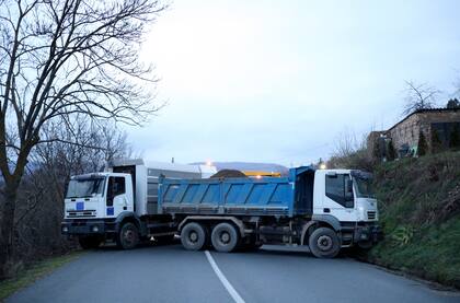 Camiones utilizados como barricada se ven en la carretera cerca de la aldea de Rudare, norte de Kosovo, sábado, 10 de diciembre de 2022. Kosovo ha pospuesto las elecciones locales que debían celebrarse el 10 de diciembre.
