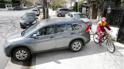 Camionetas y autos sobre la vereda de Ramón Castillo, Barrio Parque