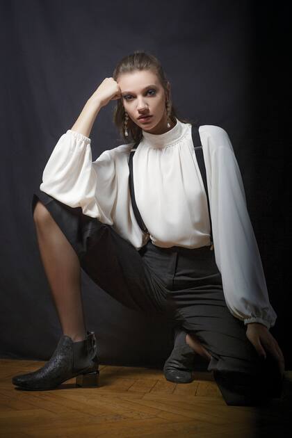 Camisa blanca de crepe con cuello alto (Prüne), pantalón bermuda de gabardina (Mishka), botas de cuero negro y taco de madera (Blaquè)