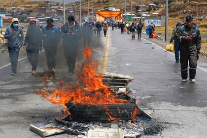 Campesinos andinos, partidarios del ex presidente Pedro Castillo, bloquean la carretera que conduce al puente internacional de Ilave, en la frontera entre Perú y Bolivia, en Puno, exigiendo la liberación de Castillo el 13 de diciembre de 2022.