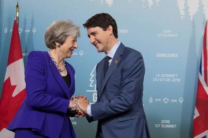 La primera ministra del Reino Unido, Theresa May, saluda al anfitrión, el primer ministro canadiense Justin Trudeau 