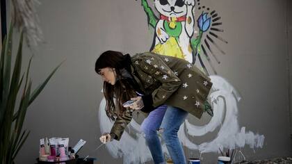 Cande pintó un mural en el local nuevo