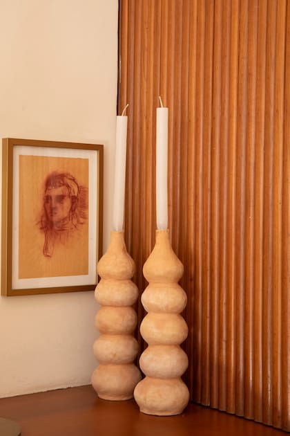 Candelabros de barro (Facón) junto a una obra de Nahuel Vecino