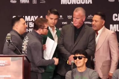 "Canelo" Álvarez encara a De la Hoya, después del volcánico discurso del representante y exboxeador; sentado, Munguía ríe