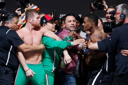 Otros tiempos: Canelo Álvarez y Daniel Jacobs durante el pesaje, y en el medio, Oscar de la Hoya, el promotor.