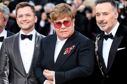 Elton, en la alfombra roja junto a su esposo y al protagonista del film