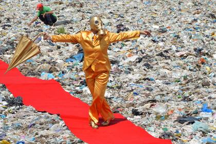 Una performer de alfombra roja interviene un basural en Brasil, en la obra de Berna Reale