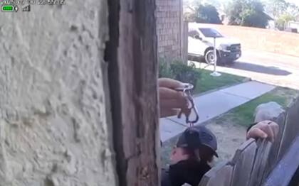 Captura de la cámara de seguridad, en la que un agente muestra que tiene las llaves de la vivienda