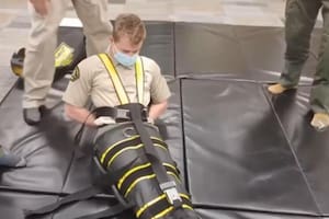 Captura de video de los agentes del ICE utilizando el dispositivo de inmovilización corporal completa llamado WRAP. Fuente: AP/Allen G. Breed