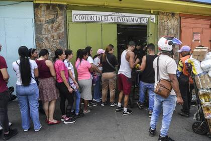 CARACAS, VENEZUELA - JANUARY 4: People line up to buy groceries in Petare, a day after the capture of Nicolas Maduro by US forces on January 4, 2026 in Caracas, Venezuela. US President Donald Trump announced on January 3 that his country's military had launched a "large-scale" attack on Venezuela and captured its President Nicolas Maduro and his wife, Cilia Flores. Venezuela faces a political and social crisis, while citizens start to struggle with the lack of supplies and water. (Photo by Carlos Becerra/Getty Images)