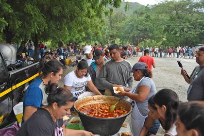 Los migrantes reciben comida de una olla popular