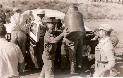 Cargando nafta en La Galera con tarros lecheros y un embudo.