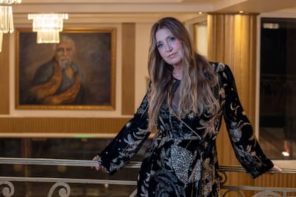 Carla Calabrese en el foyer del Maipo con el mural de Gabriel Machado que retrata de Lino Patalano