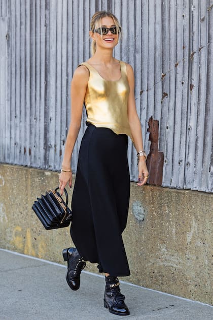 Carla Pereyra al llegar al desfile de su amiga Gabriela Hearst, lookeada por la marca: musculosa dorada, falda negra, original cartera y borceguíes Chanel.
