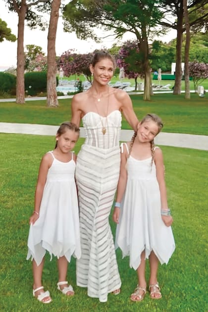 Carla, que eligió un
strapless con transparencias, al que le sumó un colgante dorado, posa junto a sus hijas,
Francesca y Valentina, con soleros iguales.