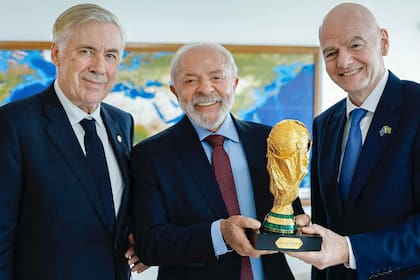 Carlo Ancelotti, el presidente brasileño Lula da Silva y el titular de la FIFA Gianni Infantino, posando con el trofeo mundial