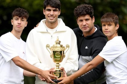 Carlos Alcaraz, con el trofeo de Wimbledon, celebrando con sus hermanos: Sergio, Álvaro y Jaime