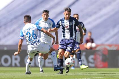 Carlos Auzqui, uno de los 4 delanteros con los que salió a jugar Talleres ante Godoy Cruz y autor de un golazo de palomita, trata de superar la marca de Damián Pérez