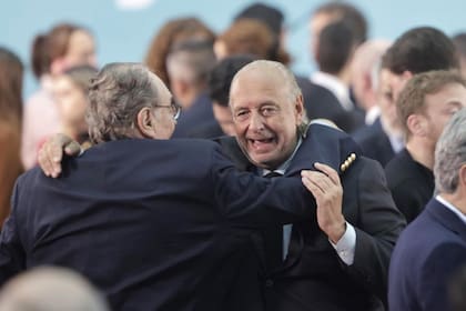 Carlos Heller se abraza con José Luis Manzano en el acto de asunción de Sergio Massa