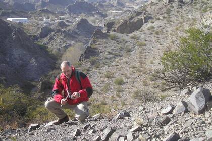 Carlos Herrmann en el distrito minero Farallón Negro, provincia de Catamarca, observando con una veta y una lupa si una veta contiene mineral