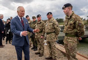 Carlos III saluda a miembros de un batallón británico durante una visita a una unidad militar conjunta en Finowfurt, Alemania