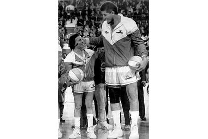 Carlos Menem le sonríe al el jugador de Jorge González, quien mide 2,35 mts. de altura, antes de iniciarse un partido solidario, el 29 de agosto de 1989