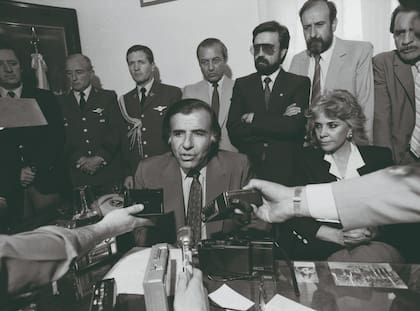 Carlos Menem, rodeado de funcionarios y periodistas, durante una conferencia de prensa en los primeros años de su gobierno