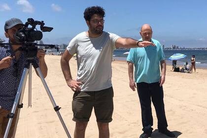 Carlos Rottemberg espera en Playa Mansa, mientras el camarografo Nicolas Mattiangeli da indicaciones