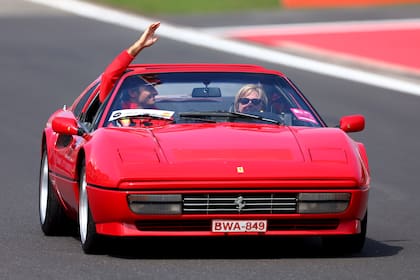 Carlos Sainz saluda durante el desfile de conductores previo al Gran Premio, a bordo de una Ferrari