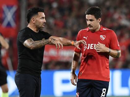 Carlos Tevez hablando con el uruguayo Neves, en su ciclo con Independiente