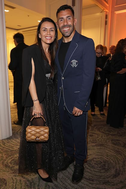 Carlos Tévez y su mujer, Vanesa Mansilla, con un transparencias, blazer-capa y una cartera de Louis Vuitton. Comprometido con la causa, el DT viajó especialmente desde Córdoba, donde dirige a Talleres, para estar en la gala