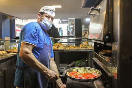 Carlos tiene años como maestro pizzero en Banchero.