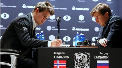 Carlsen toma nota; Karjakin observa el tablero. El campeón y el retador no se sacaron ventajas aún