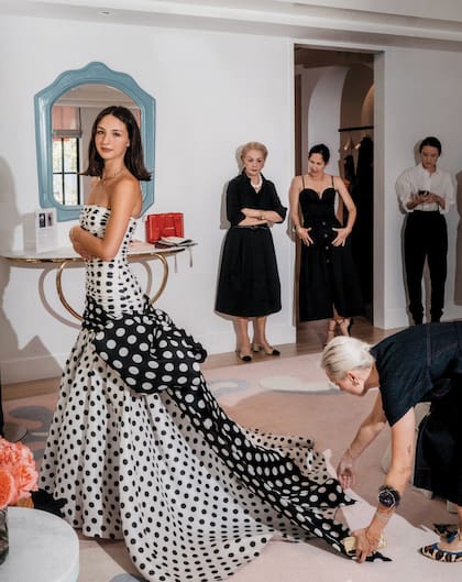 Carolina espera que una modista haga los últimos ajustes al vestido, bajo la mirada de dos expertas: su abuela, Carolina Herrera, y su madre, Patricia