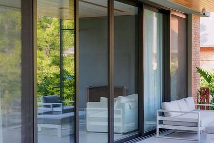 Carpintería corrediza de 6 hojas de la línea 'High Design Slide' con perfileria Rehau, foliado en color negro mate con mosquitero y vidrios DVH Laminados (Procrisa).