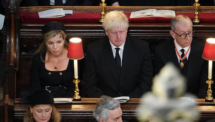 Carrie Johnson (izquierda), esposa del ex primer ministro británico Boris Johnson (centro), y Philip May toman asiento dentro de la Abadía de Westminster 