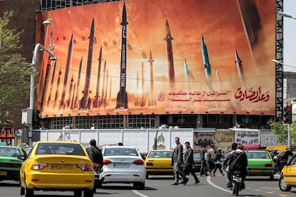 Cartel que muestra misiles balísticos iraníes en servicio con nombres, con un texto en árabe que dice "la promesa [de la persona] honesta" y en persa "Israel es más débil que una telaraña", en la plaza Valiasr en el centro de Teherán el 15 de abril de 2024.