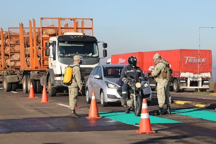 Patrullas militares uruguaya controlan a conductores de vehículos en el puesto de aduana en la frontera con Brasil