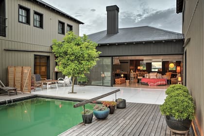 La galería es el corazón de la casa. La forma de ‘U’ es ideal para contener el espacio y generar distintos climas. El living de afuera es el lugar preferido durante el verano. El perfume del limonero y las azaleas inunda el espacio y el biombo de caña le da intimidad y transparencia.