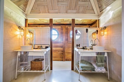 El baño de la planta superior está diseñado con interesantes texturas y transparencias que dividen pero no cierran.