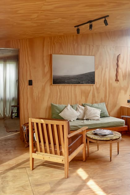 Casa Noble tiene la misma paleta y materiales que la casa grande. Los sillónes con almohadones de lino en verde se repiten en ambos livings.