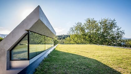 Aquí se ven los ventanales de vidrio sobre el terreno que le otorgan luz natural al interior