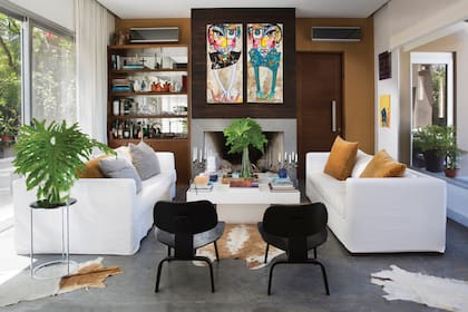 Los tonos neutros dominan la casa. En el living se imponen dos cuadros de Daniel Genovesi, que se posan en medio de los sillones cubo con almohadones de lino y terciopelo.