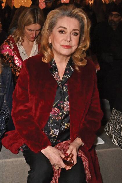 Catherine Deneuve llevó un abrigo de terciopelo, una camisa de estampa floral y un pantalón sastrero.